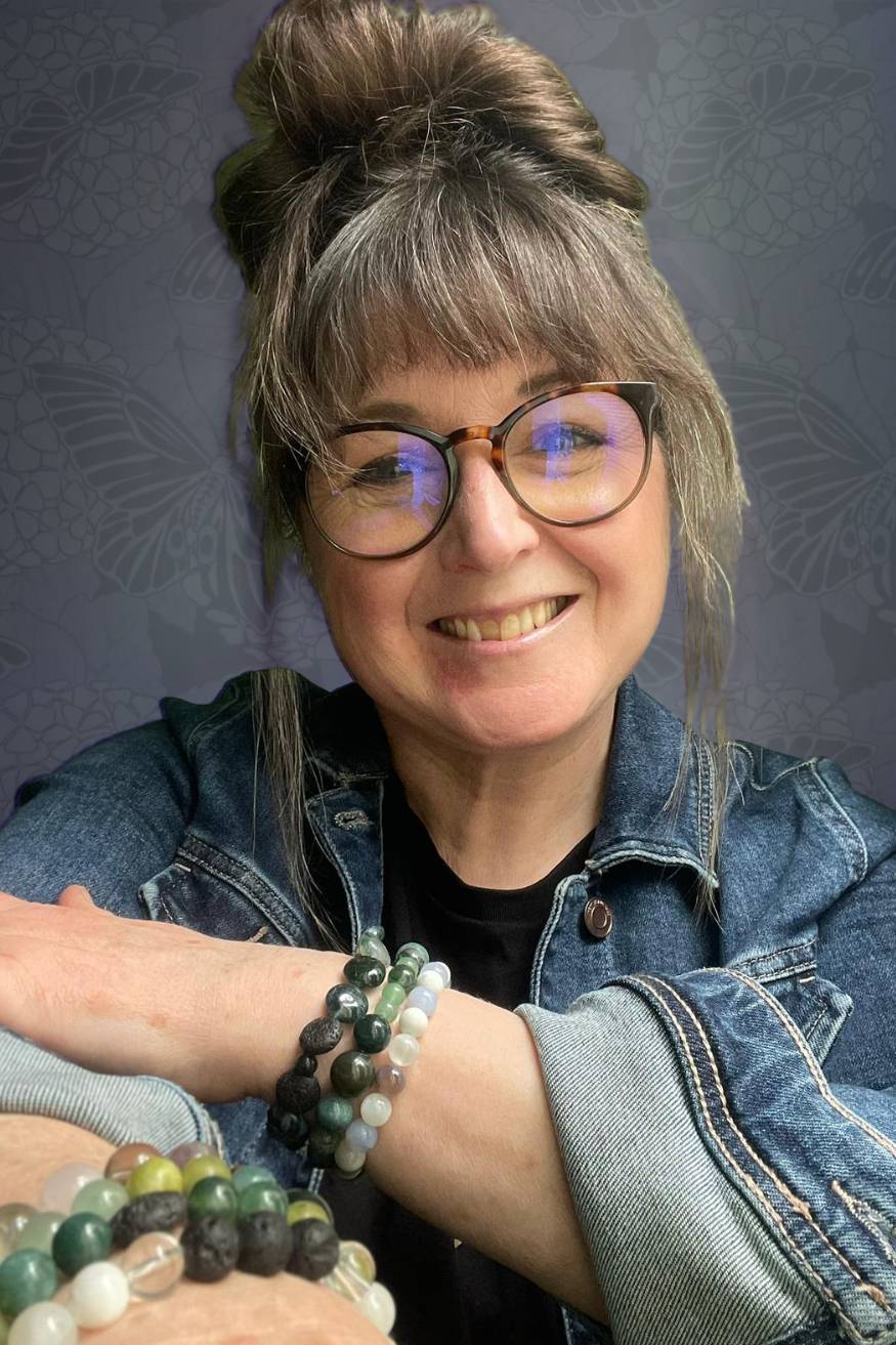Mairi Taylor, menopause and menstruality mentor serving Barrow upon Soar, smiling in a denim jacket with crystal bracelets.